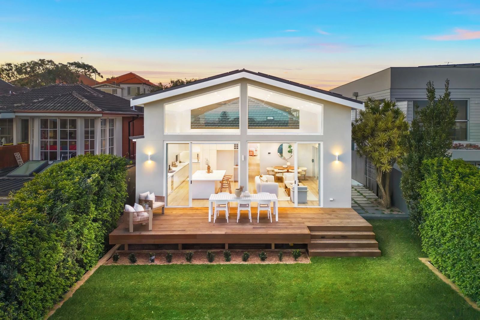 Wallace Street, Kingsford — After renovation — rear facade at dusk with gabled glazing, deck and landscaped lawn