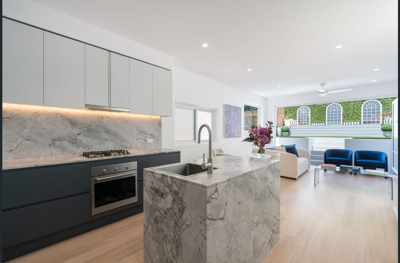 Clayton Street, Balmain — After renovation — open-plan kitchen and living area with marble island and garden outlook